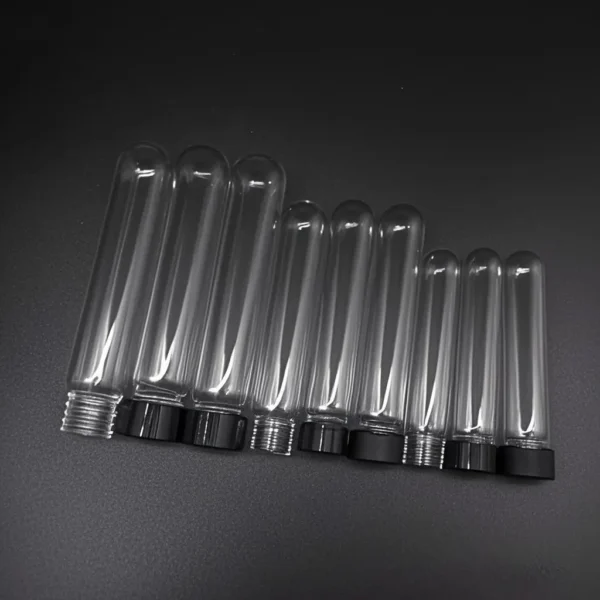 Quartz Round Bottom Threaded Vials | Fused Silica Screw Cap Tubes 1 A collection of clear quartz round bottom threaded vials in various sizes, with some capped with black screw caps, arranged on a dark surface.