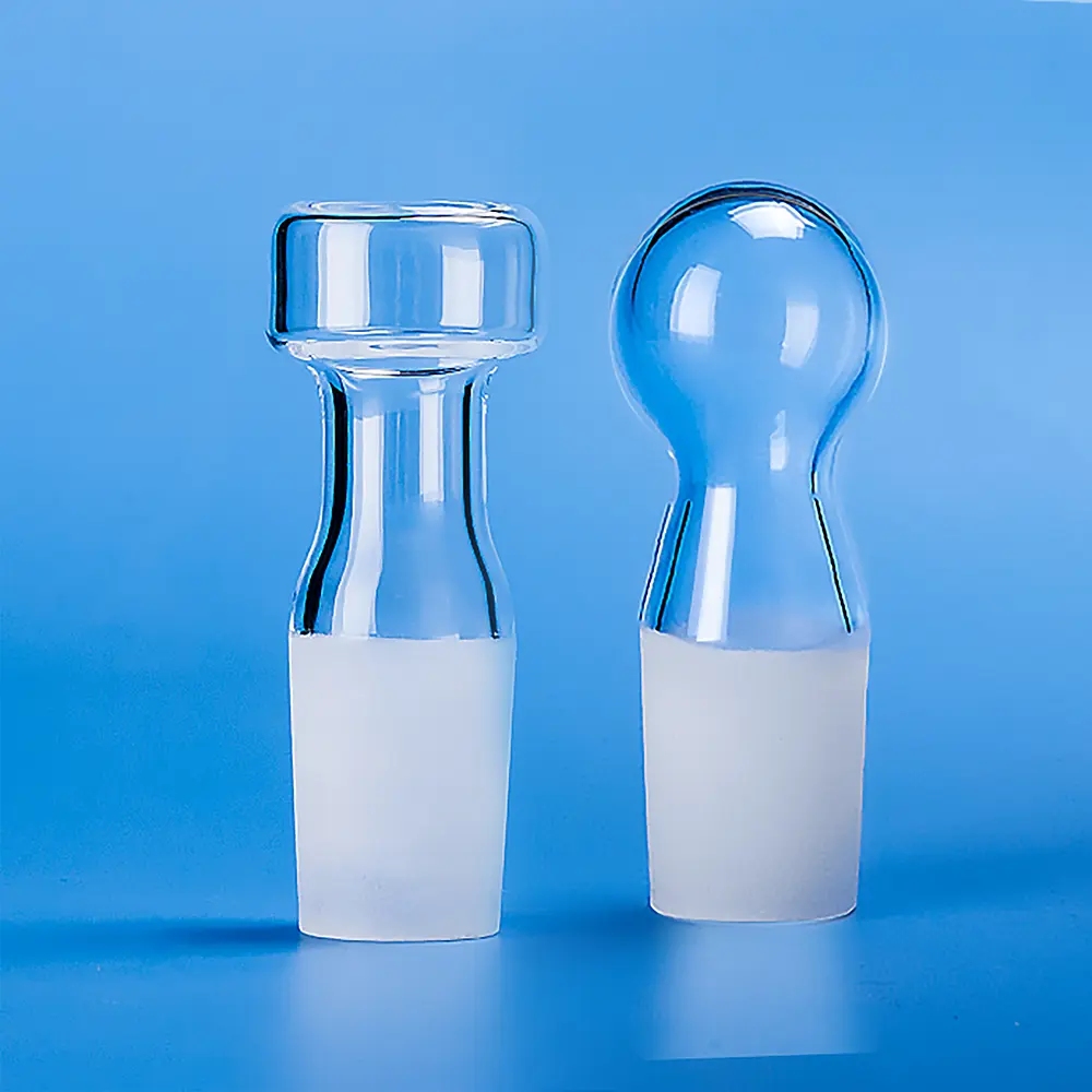 Quartz Glass Plugs | Fused Silica Laboratory Stoppers 1 Two clear quartz glass plugs with frosted ground joints, showcasing different head shapes (cylindrical and spherical) for laboratory applications.