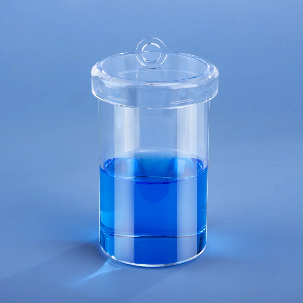 Quartz Straight-Wall Crucible with Lid | Fused Silica Cylindrical Crucible 1 A clear quartz straight-wall crucible with a lid, containing a blue liquid, set against a solid blue background.