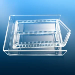 A clear, rectangular high-purity slotted quartz boat nested within a larger quartz carrier tray on a blue background.