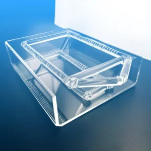 An angled view of a clear, rectangular high-purity slotted quartz boat, demonstrating its handles and the detailed slotting for precise sample placement.